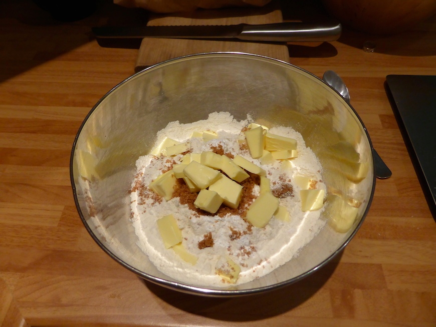 The dry ingredients in a mixing bowl - butter, flour, baking powder and sugar.